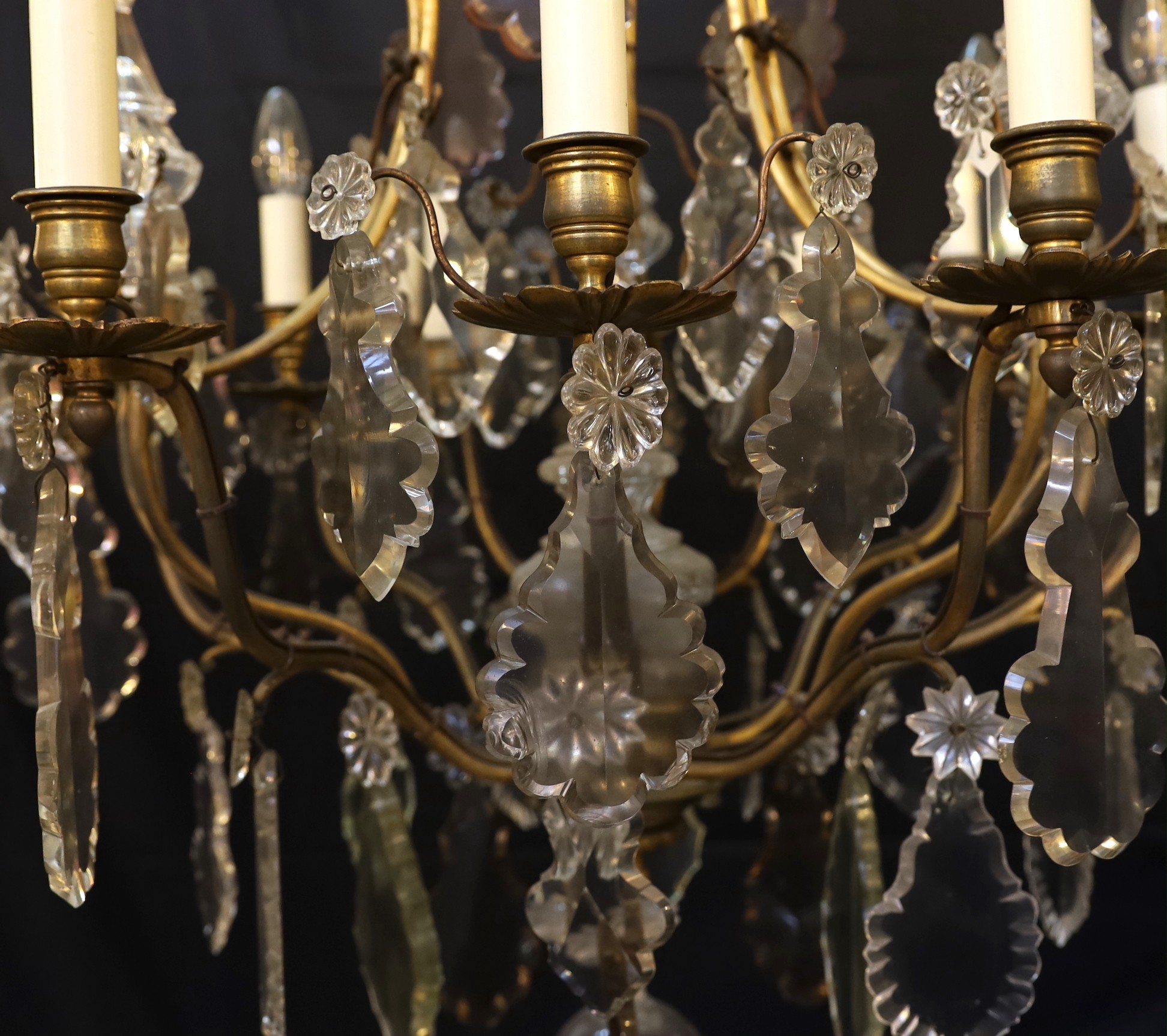 An early 20th century French gilt bronze and cut glass eight light chandelier profusely hung with lozenge and flowerhead drops, drop 110cm. width 65cm